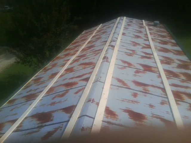 Rusted metal roof panels with new wood purlins before replacement — Storm Damage Roof Repair in Pittsford by Roofing Brothers