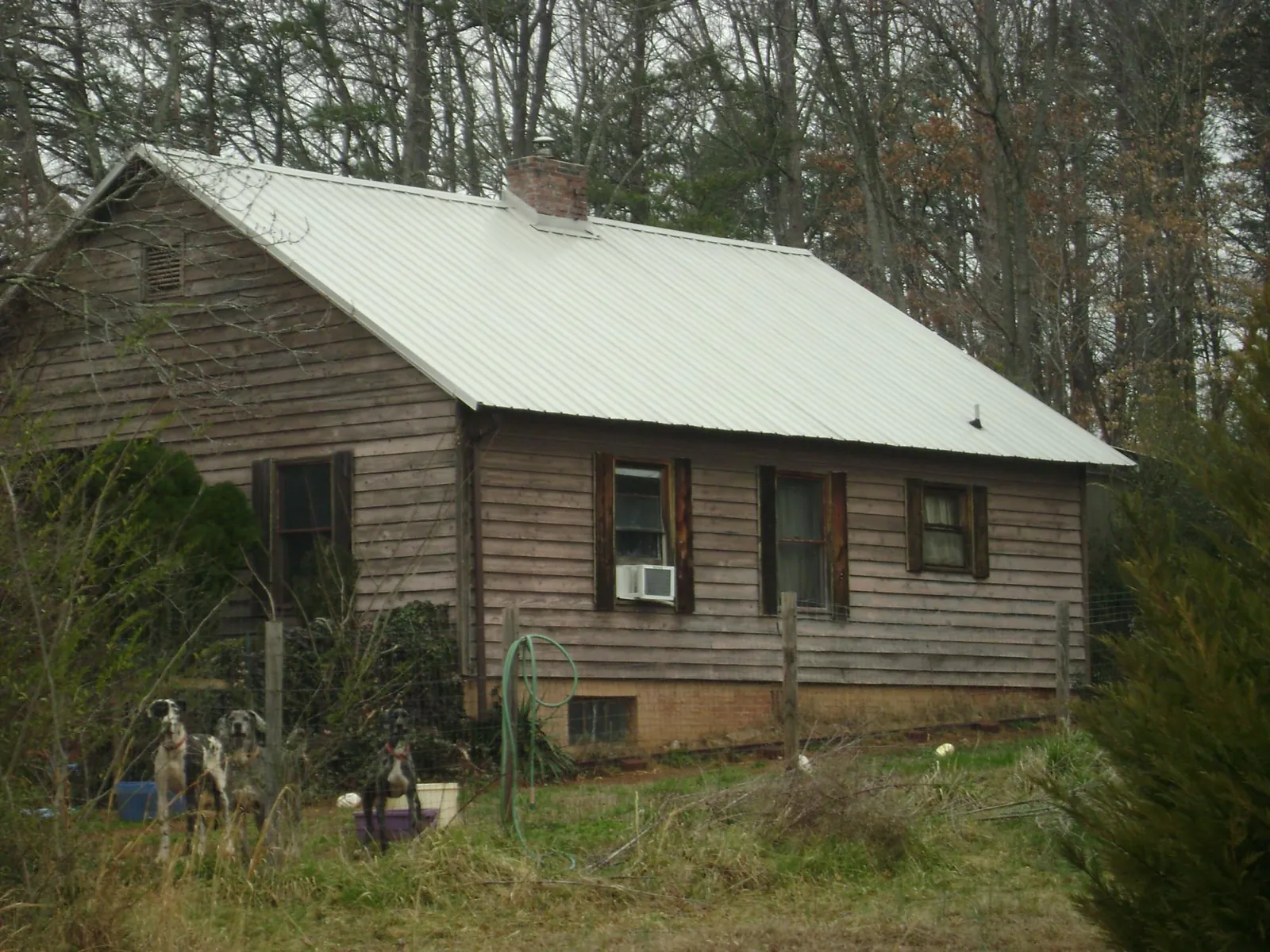 White metal roof on an old wood sided farmhouse, from a Metal Roof Installation job in Pittsford
